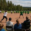 Två lag som spelar brännboll med åskådare i förgrunden